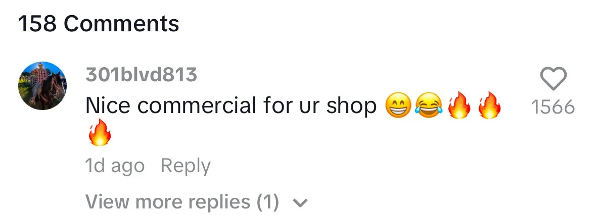 Screenshot of a social media comment section showing one comment that says, 'Nice commercial for ur shop' with smiling, laughing, and fire emojis. The comment has 1566 likes and one reply.
