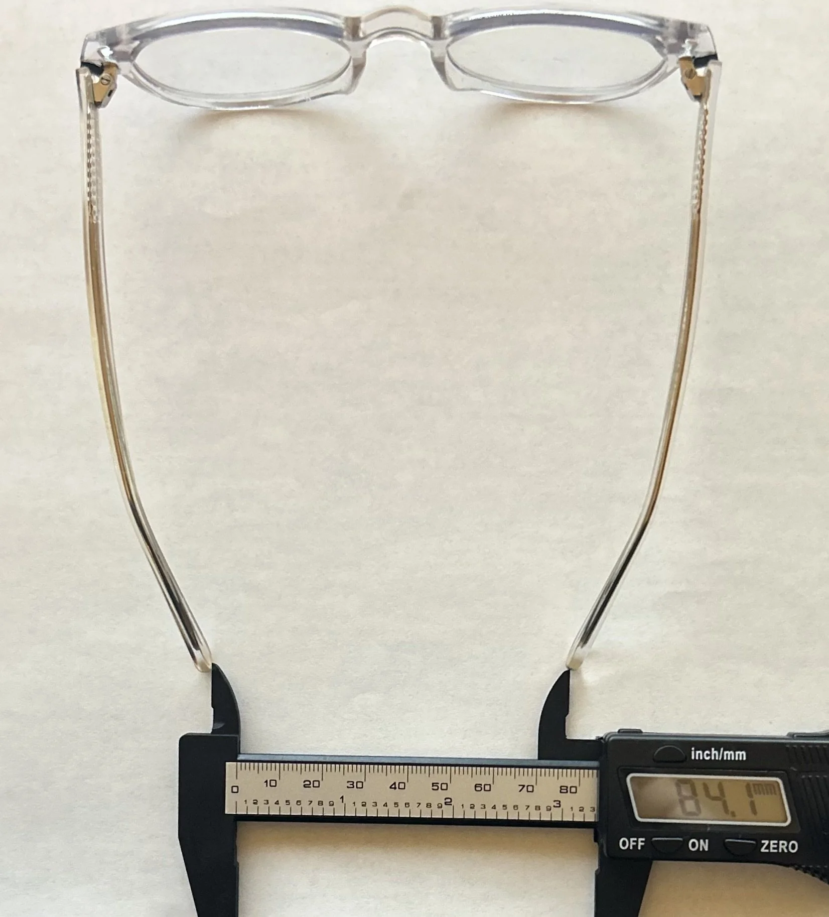 Digital caliper measuring a pair of glasses at 84.7 millimeters wide with Big Fixer applied.