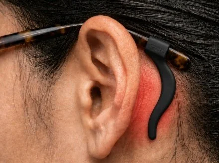 Black silicone glasses ear hook worn behind the ear, with redness highlighting potential skin irritation.