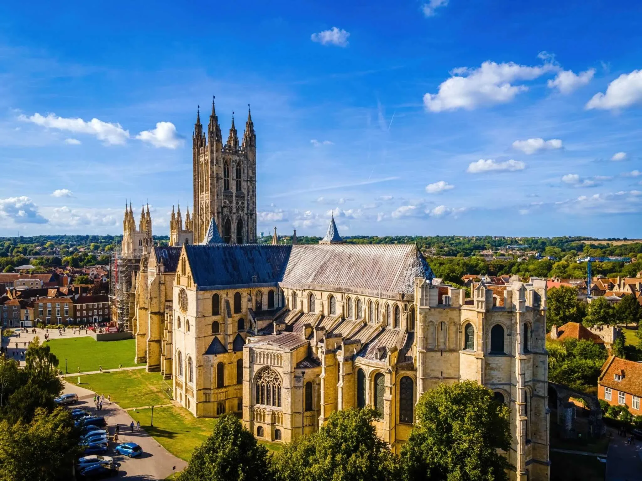 Aerial view of Canterbury Cathedral in England with blue sky and clouds.