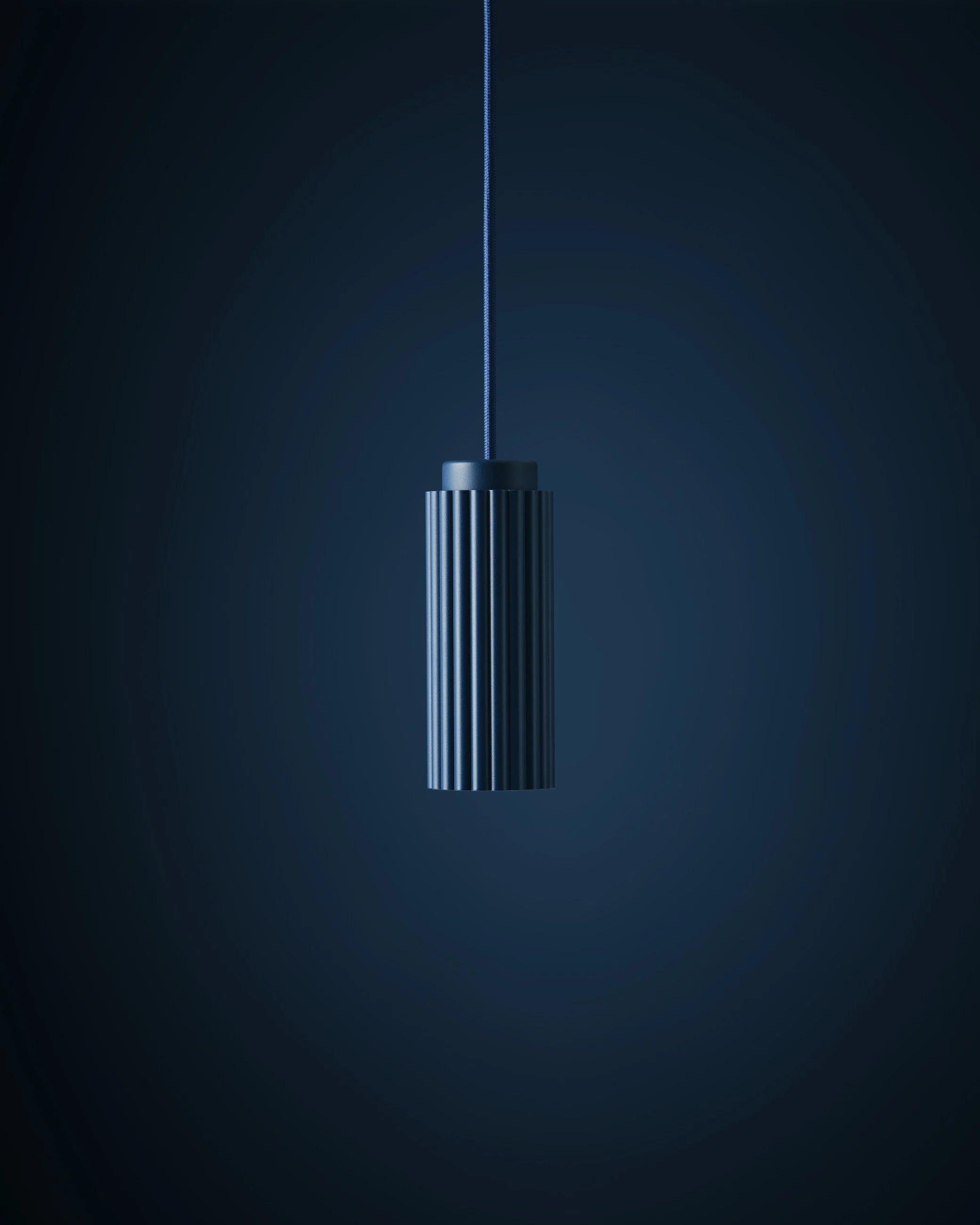 Blue vertical pendant light fixture hanging from a thin cord against a dark background.