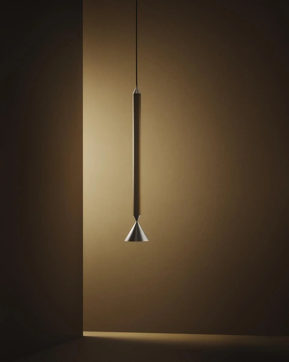 Modern pendant light fixture hanging from the ceiling in a minimalist room, with a smooth, neutral wall background.