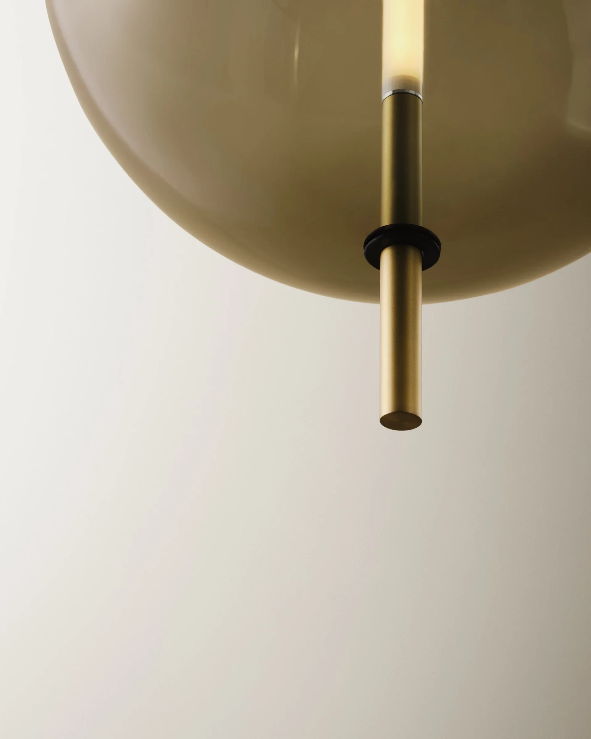 Close-up of a modern ceiling light fixture with a metallic stem and a rounded shade.