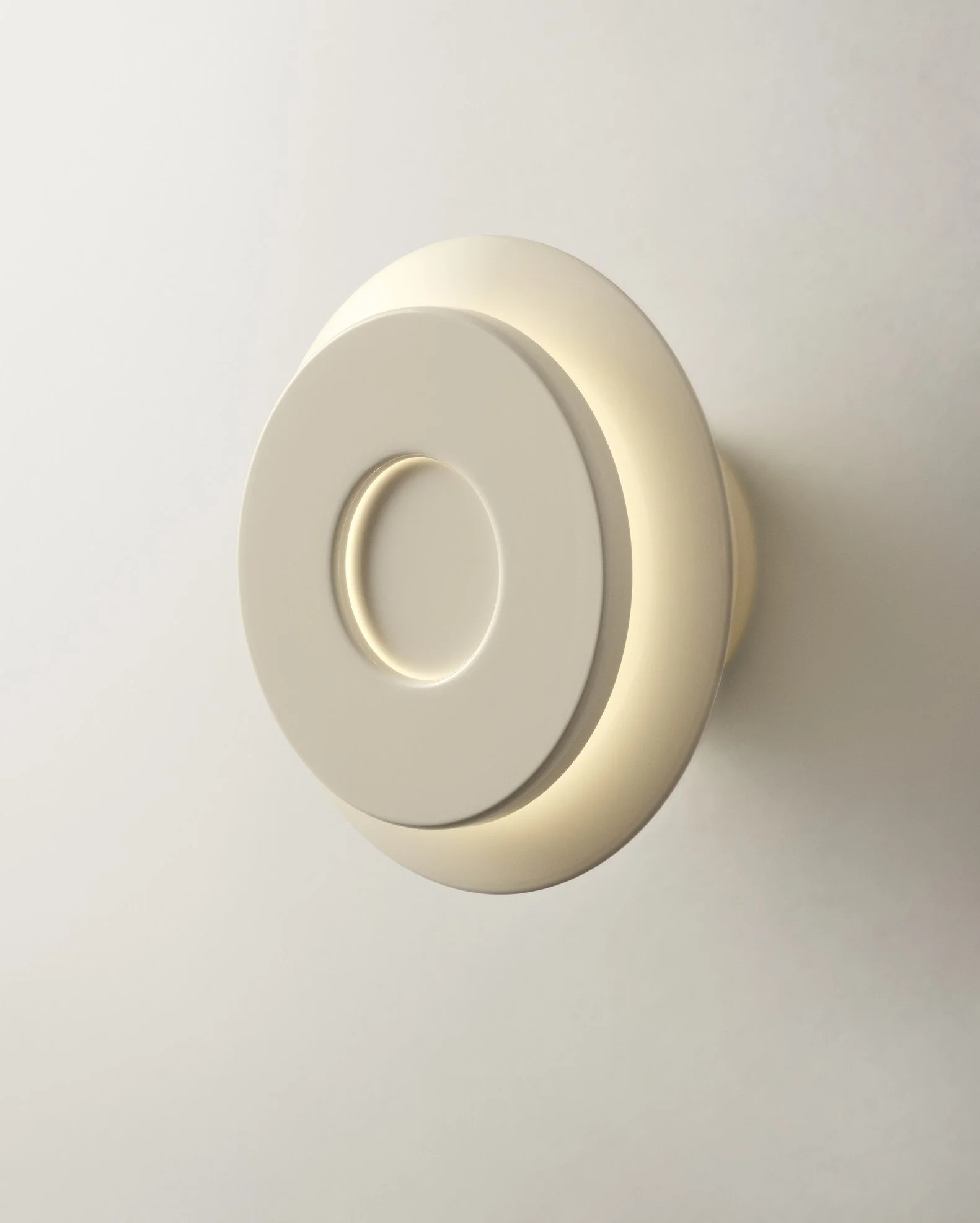 Close-up of a modern, minimalistic, circular, beige wall light fixture mounted on a white wall.