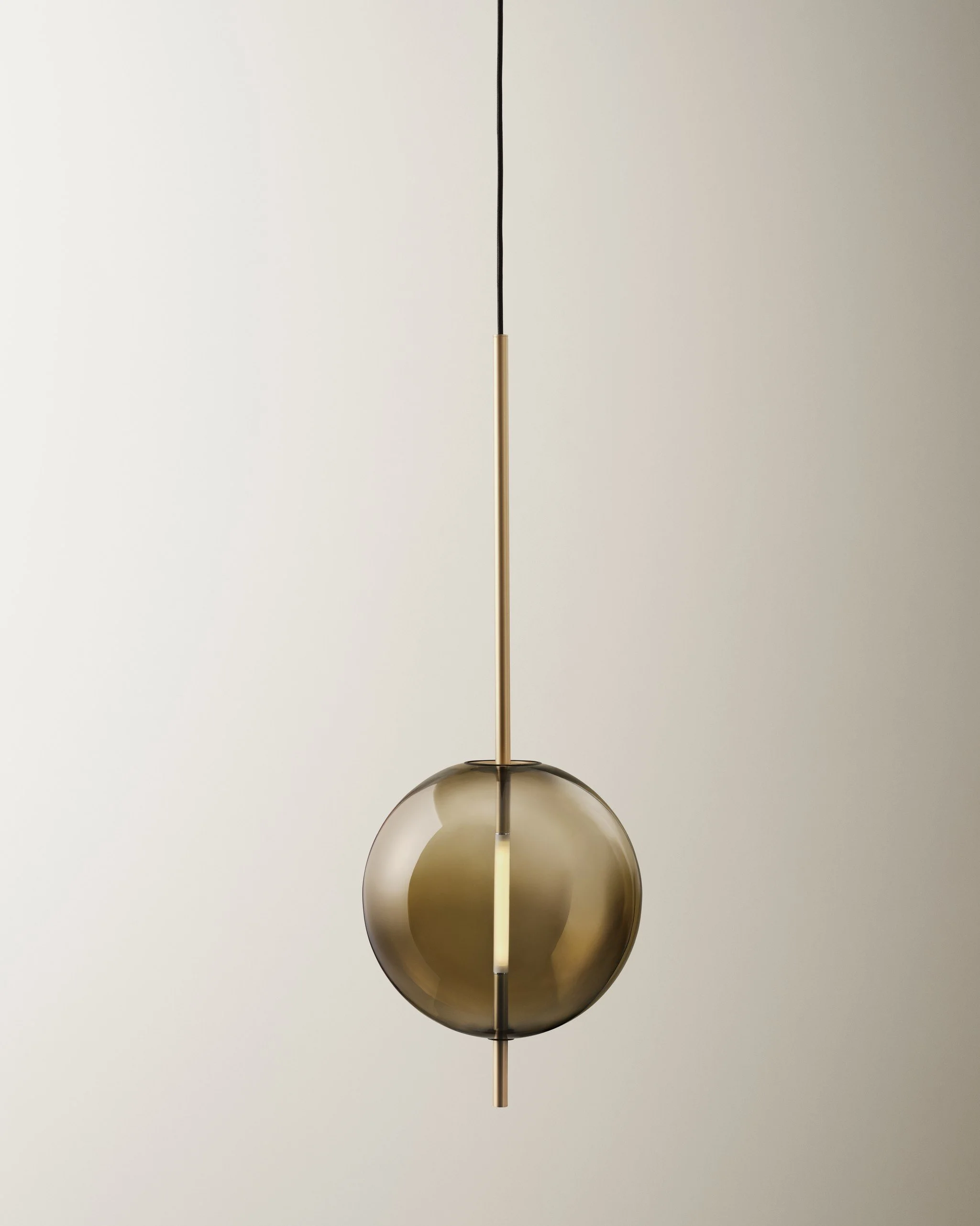 Modern pendant light fixture with a spherical glass shade and a vertical gold rod, hanging from a black cord, against a plain background.