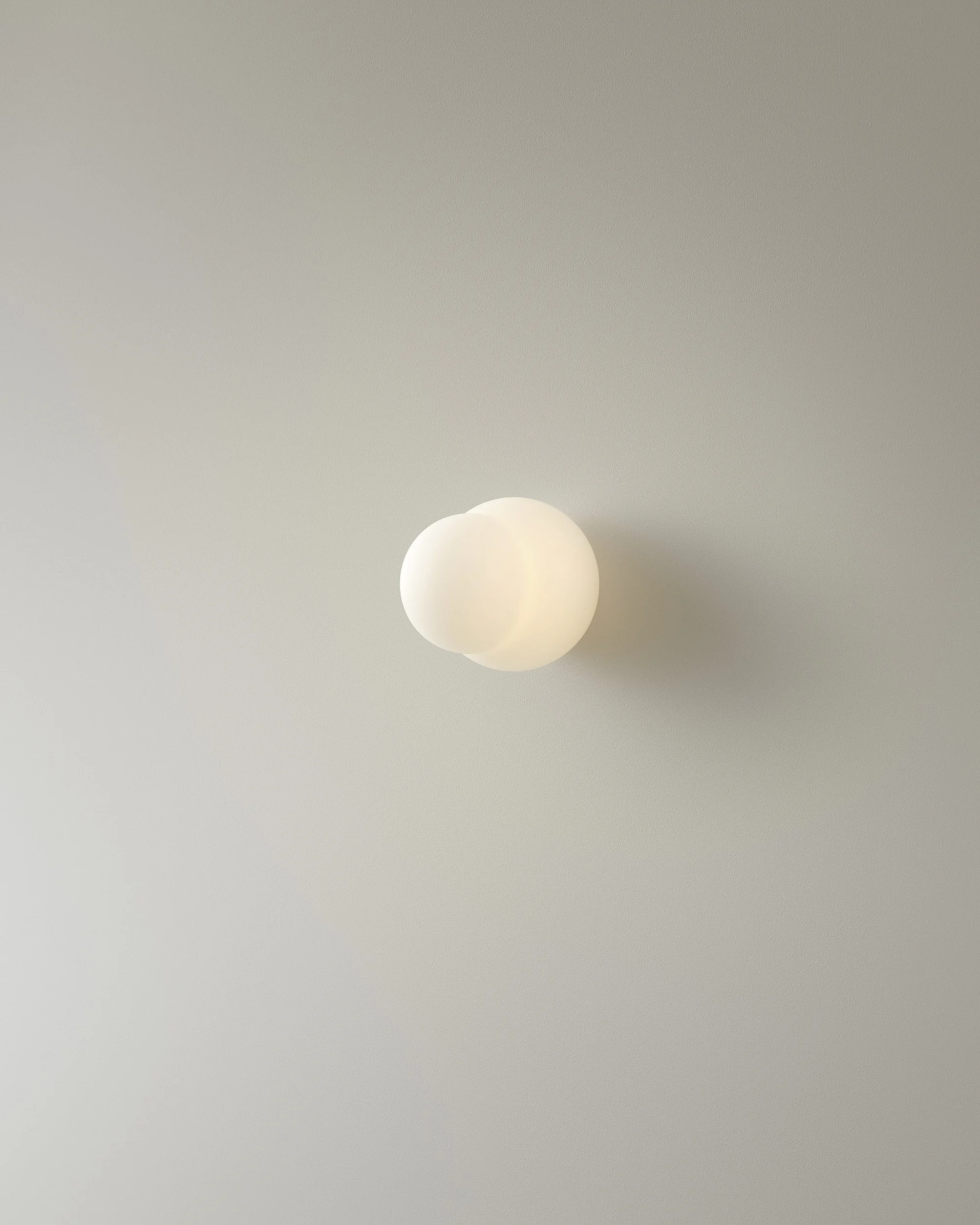 Minimalist wall-mounted light fixture on a plain wall.