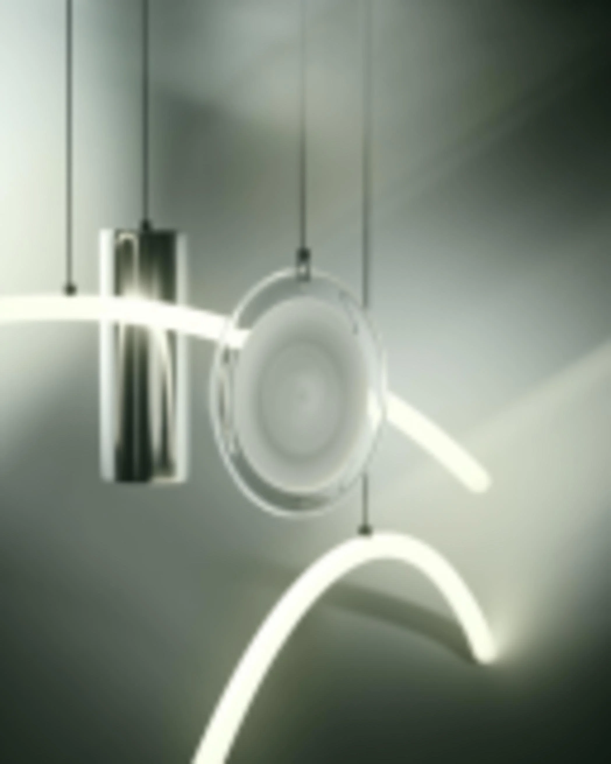 Abstract close-up of a ceiling light fixture with a curved illuminated tube, a circular center, and attached hanging elements in a modern interior.