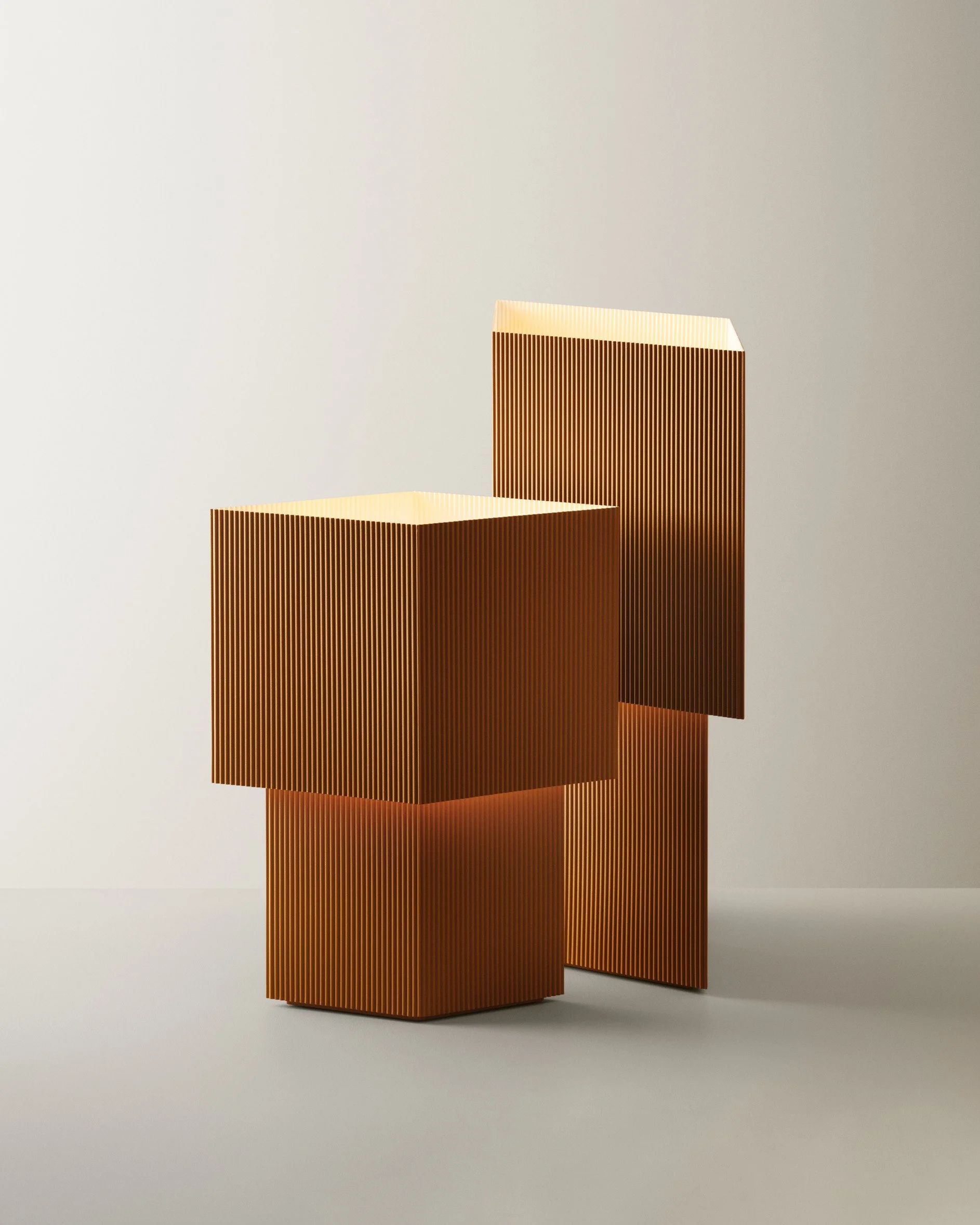 Three modern copper-colored decorative boxes with vertical ridges, stacked creatively on a light gray background.