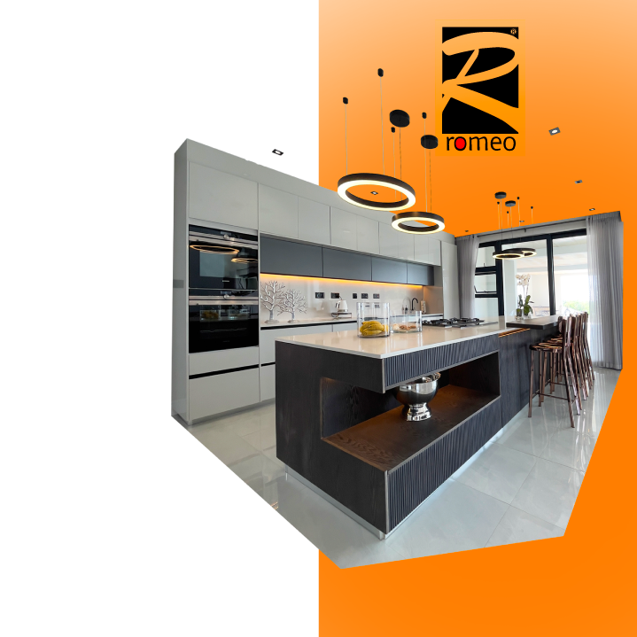 Modern kitchen with white and black cabinetry, an island with a beige countertop, orange ceiling with circular pendant lights, and a dining area with bar stools near a large window with curtains.