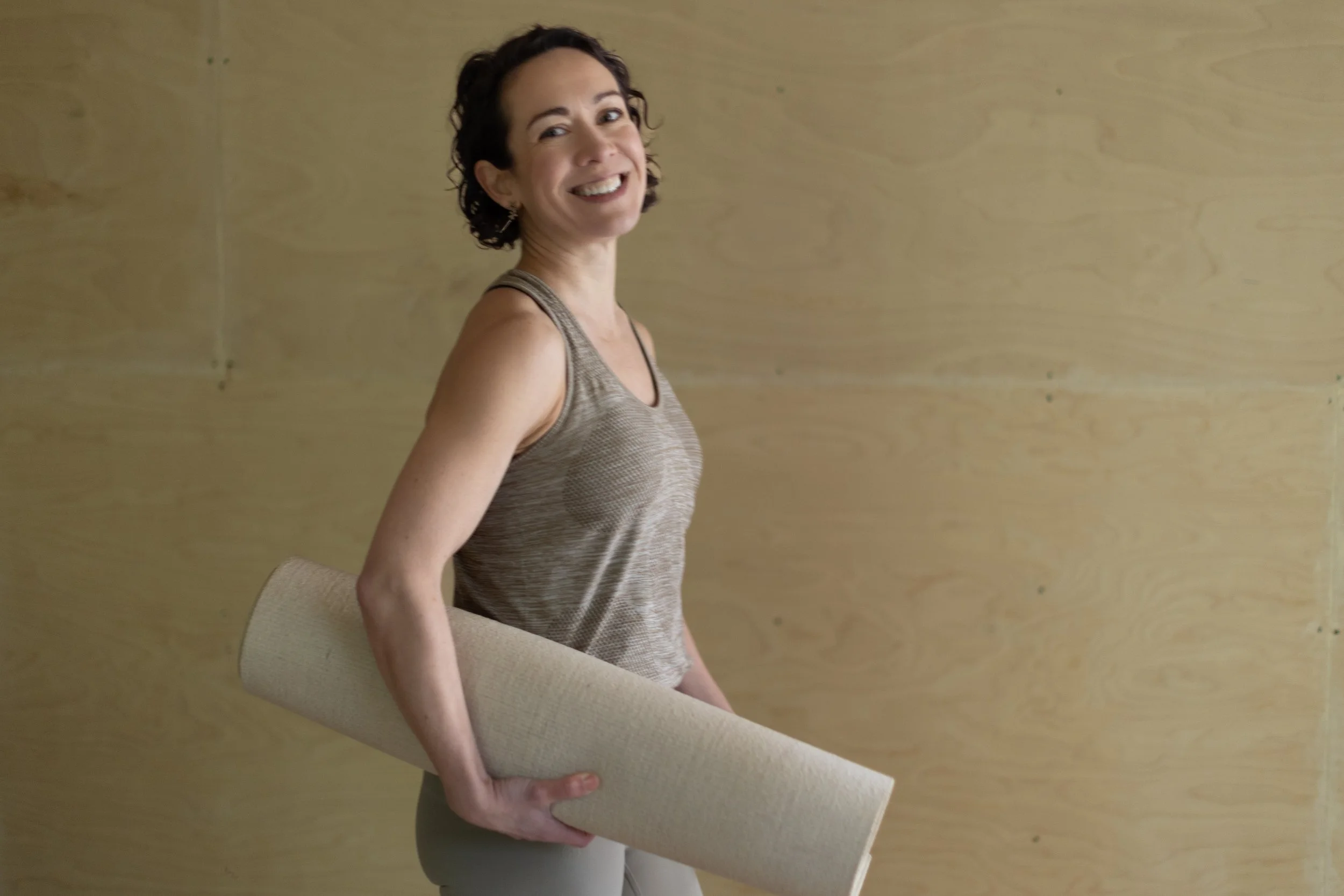 Teacher Alice carrying a yoga mat