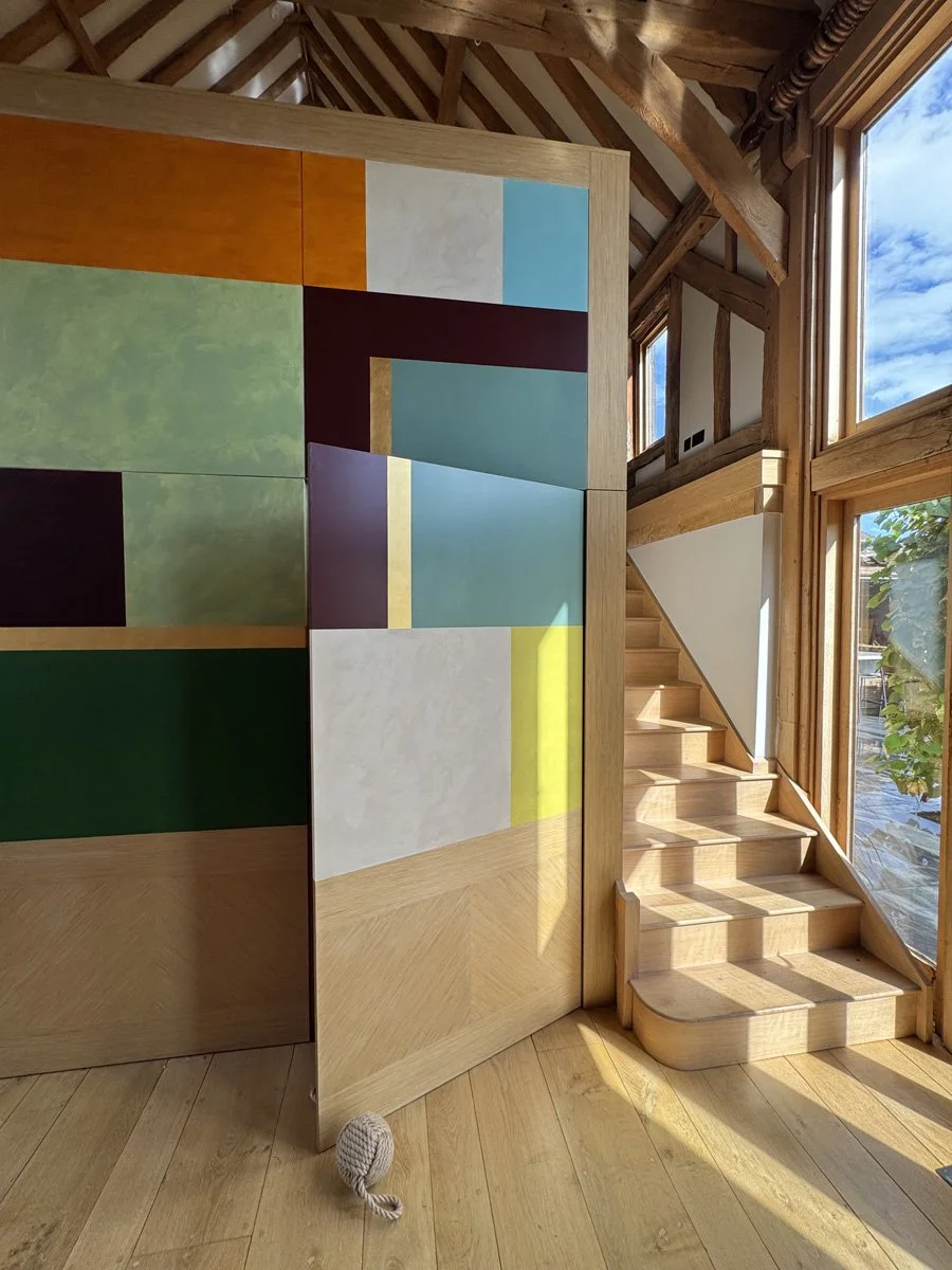 beamed barn conversion interior with detail of modern vibrant colour block mural