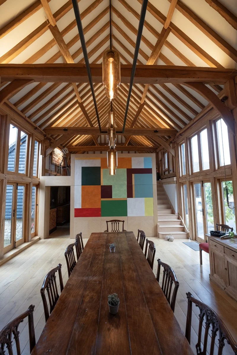 beamed barn conversion interior with modern vibrant colour block mural