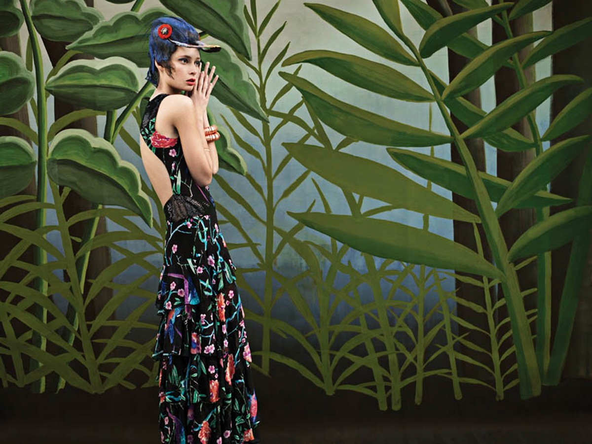 Vibrant patterns inspired by painter Henri Rousseau, jungle-themed. whimsical and bohemian aesthetic, with models posing against lush, theatrical backdrops featuring oversized foliage.