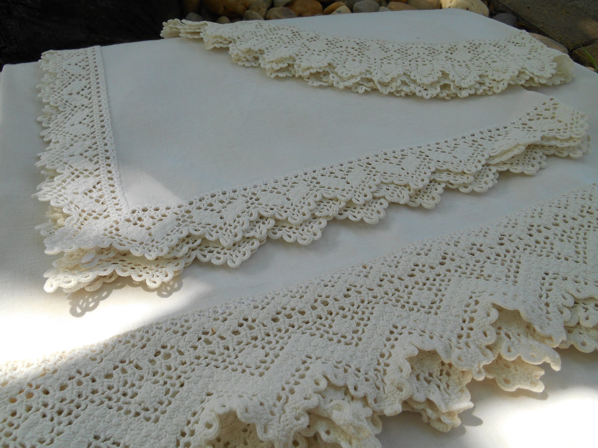 Colored felt cutouts and felted wool yarn arranged on a pink felt background, with leaf shapes in orange, yellow, pink, and purple, and small wool bundles.