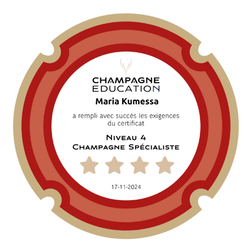 A circular award badge with a red and beige border. Champagne Specialist Badge, from comité Champagne. Inside, there is a 4-star rating underneath.
