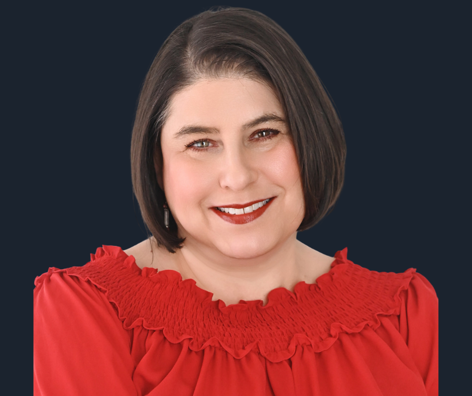 A woman with short brown hair, wearing a red top with ruffled detailing around the collar, smiling against a white background.
