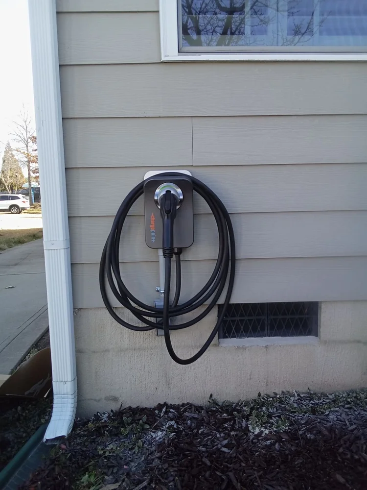 Wall-mounted EV charging equipment on an exterior house wall