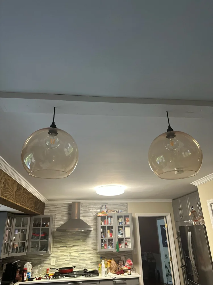 Two glass pendant lights over a kitchen counter