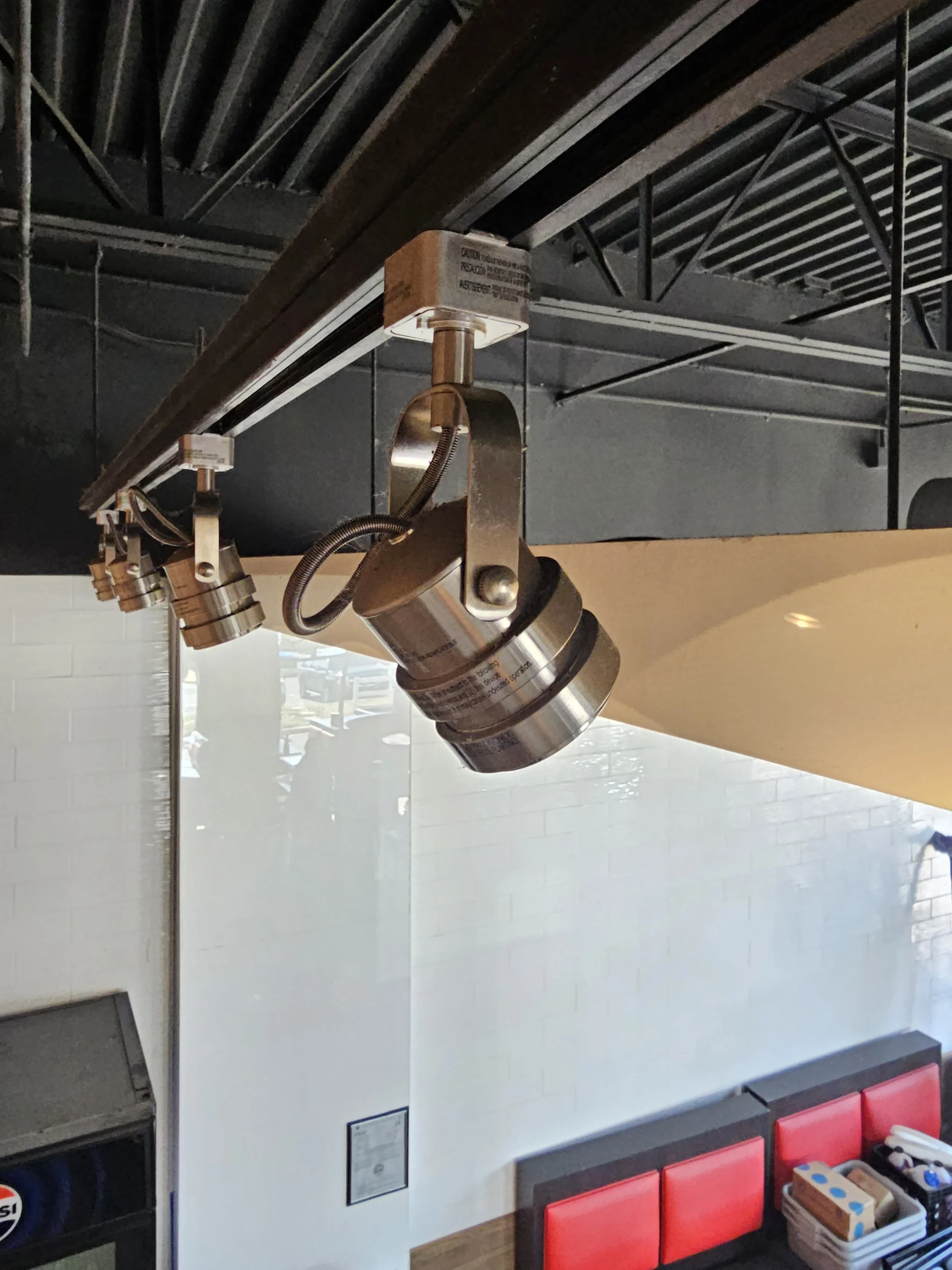 Adjustable track-light fixtures in a commercial interior. Commercial lighting work by Loftis Lighting & Electrical.