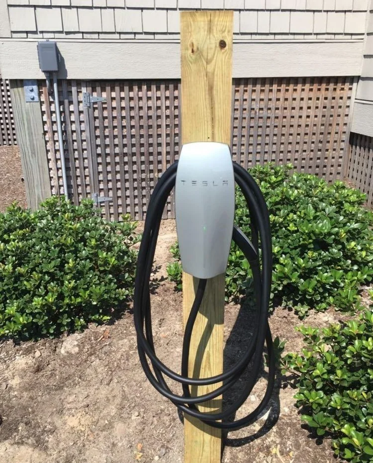 Tesla Wall Connector mounted on an outdoor wooden post