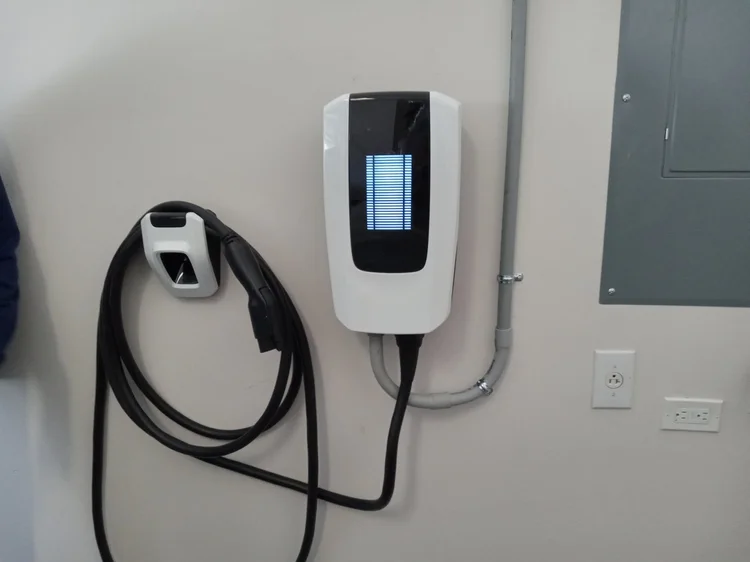 Wall-mounted home EV charger with a separate connector holder.