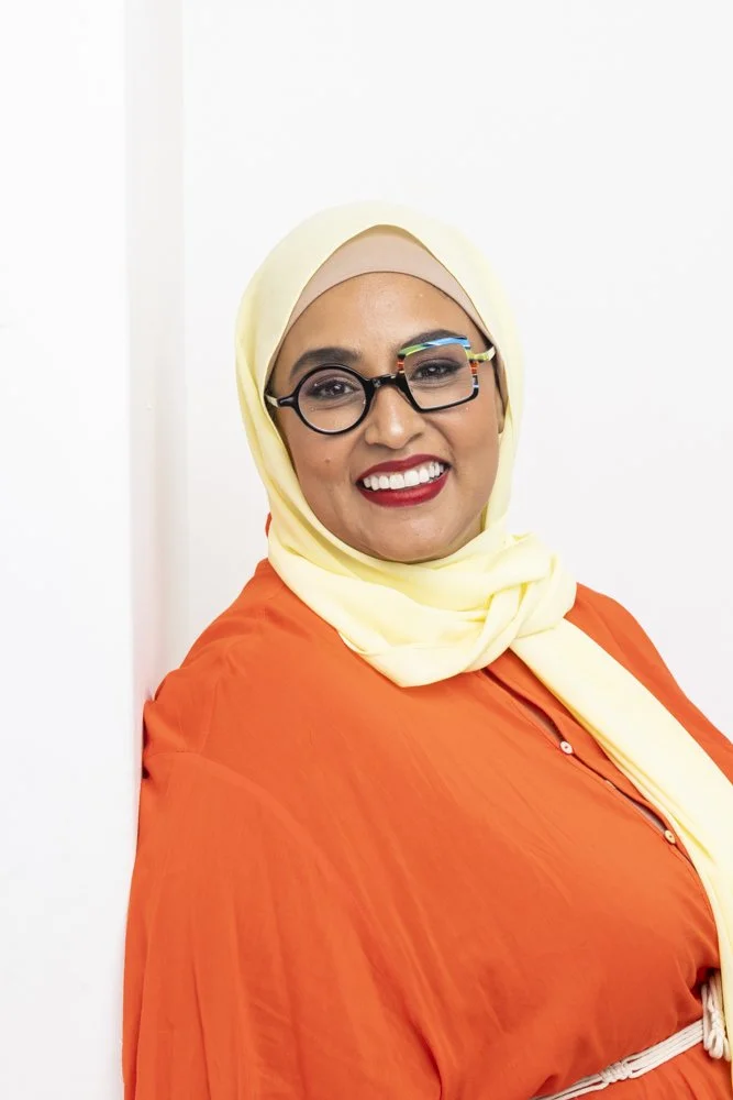 Two people standing side by side, each holding notebooks and folders against their chests.