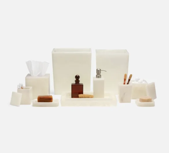 Assorted soap and hygiene products on a white background, including tissue box, soap bars, lotion dispenser, and wooden brushes.