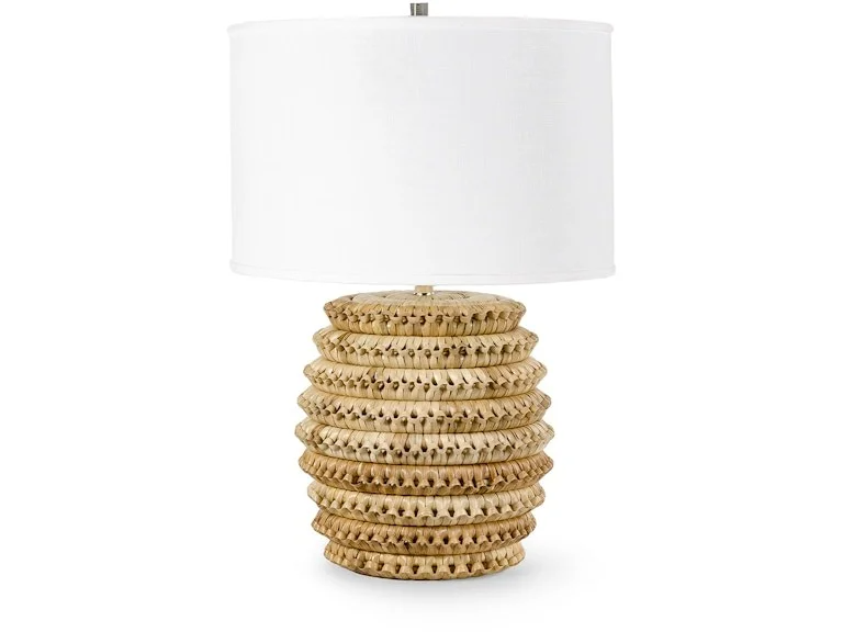 Table lamp with a base made of stacked woven rattan discs and a white fabric lampshade