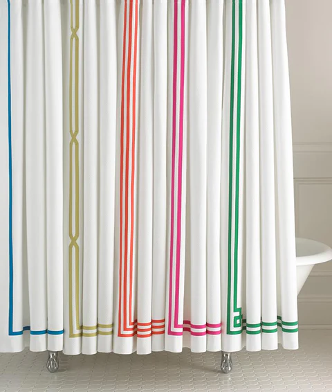 Bright white curtain with vertical colorful stripes in yellow, orange, pink, and green, in a modern bathroom setting.
