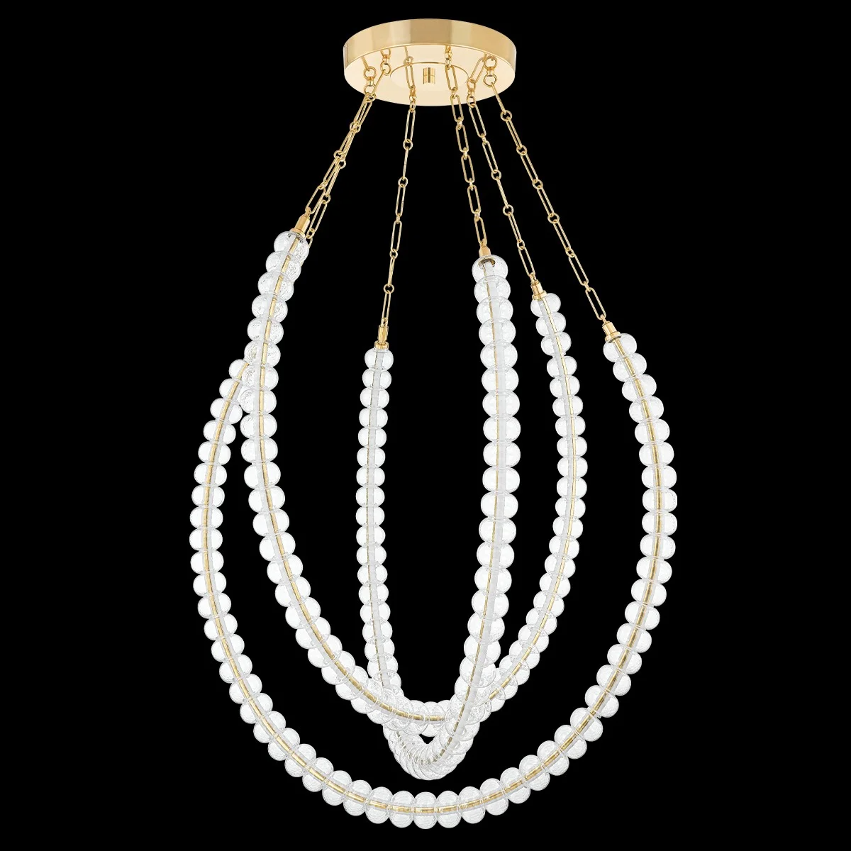A chandelier with multiple strands of white beads hanging from a gold circular top against a black background.