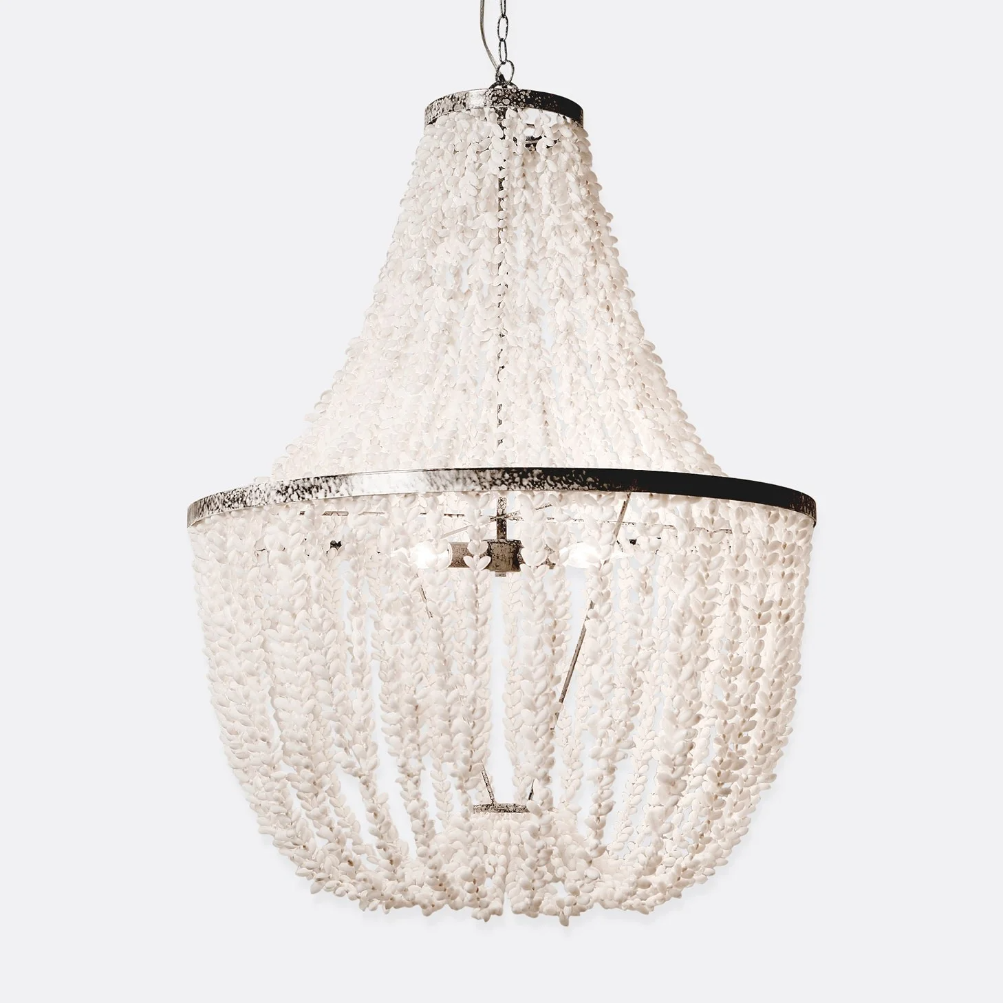 A large, decorative white chandelier with shells or bead-like ornaments, hanging from a chain.