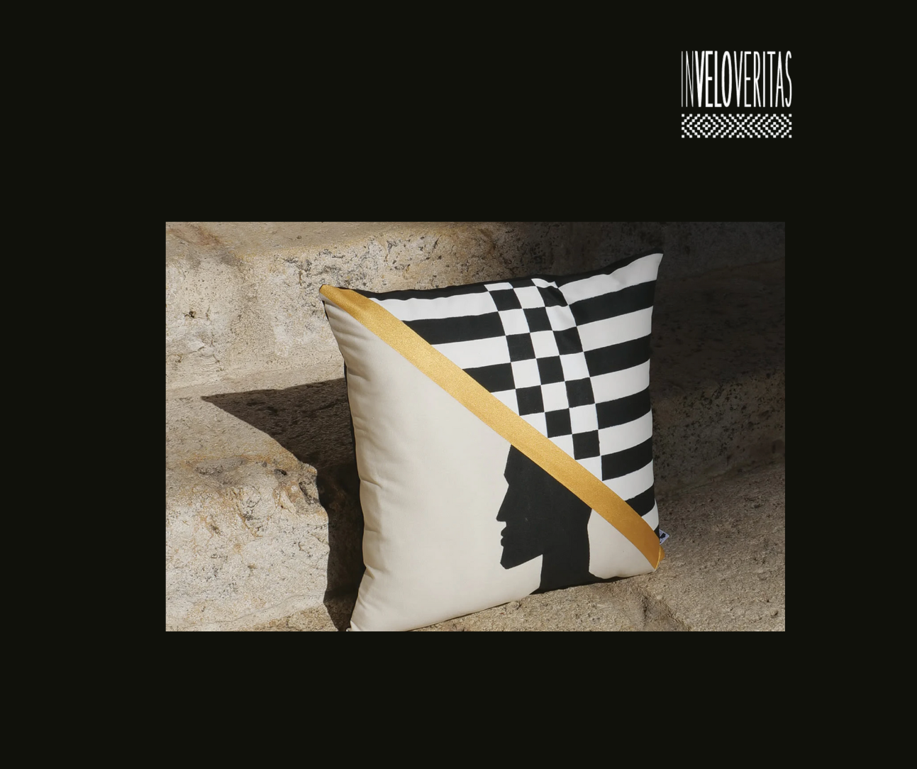 Cuscino decorativo con design nero e bianco a scacchi e silhouette di una testa di profile, con una fascia dorata diagonale e la scritta 'Inveloveritas' in alto a destra.