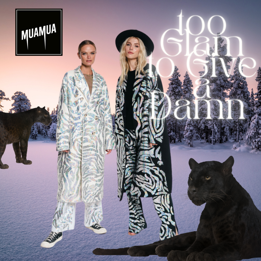 Due donne vestite con abiti con motivi zebra, una con cappello nero, in un paesaggio invernale con neve e alberi coperti di neve. Ci sono anche due pantere nere, una seduta in primo piano e l'altra in piedi sulla neve, e un leopardo nero sullo sfondo