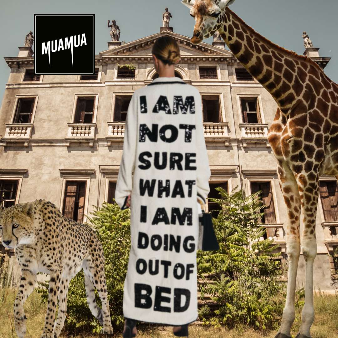 Una donna con un cappotto con scritta 'I am not sure what I am doing out of bed' davanti a un edificio storico, con giraffe e ghepardi intorno.