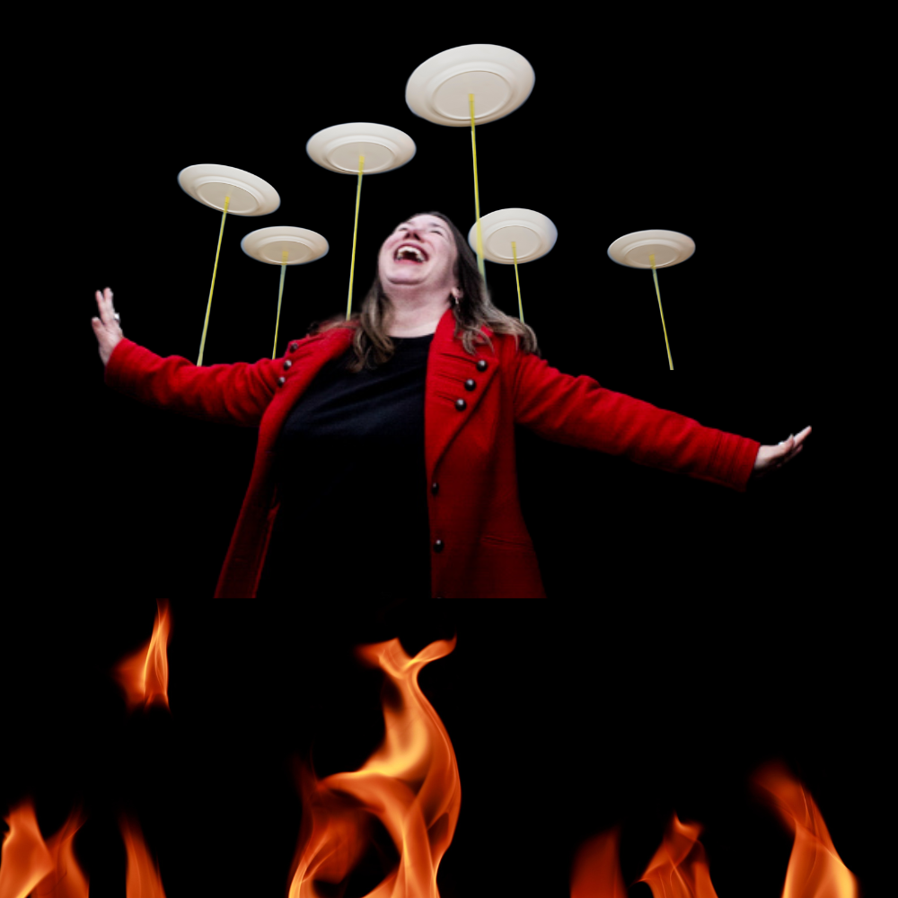 A person in a red coat joyfully balancing spinning plates on sticks against a black background, with flames below.