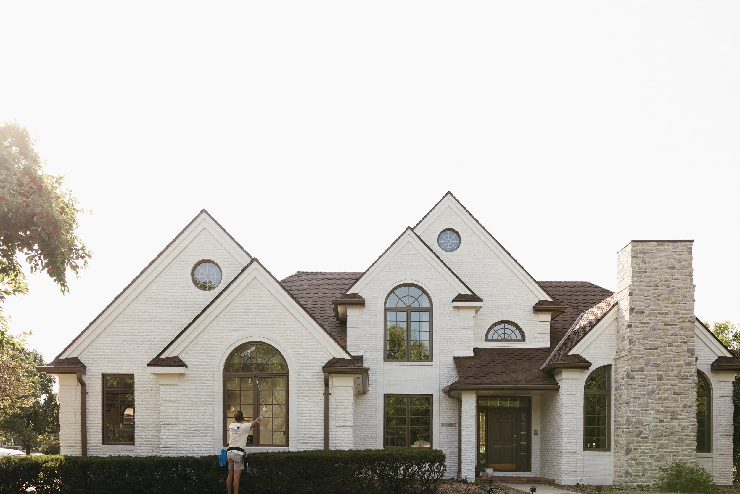 Birdie Window Cleaning technician performing residential window cleaning service in Waukee, IA using professional tools.