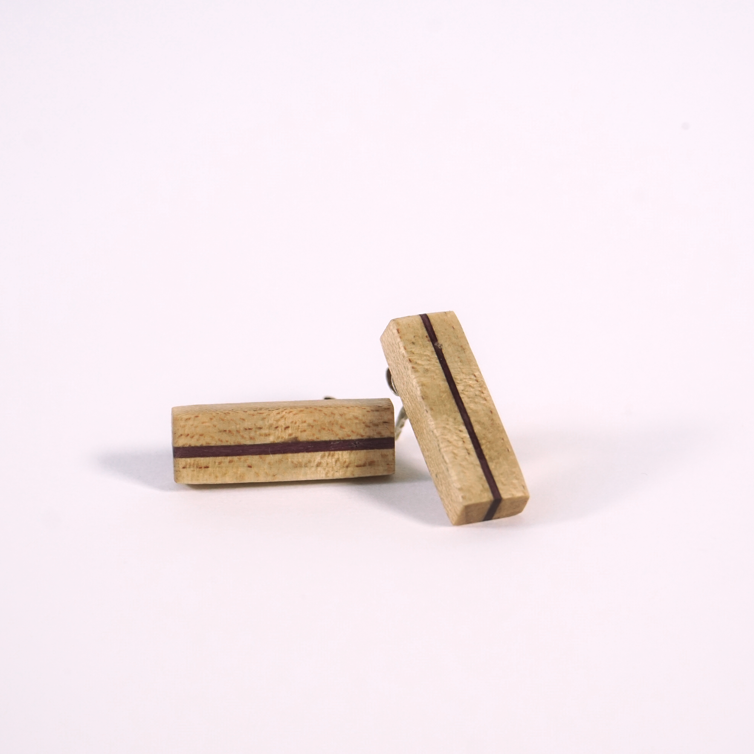 Vue d'un chemin pavé s'étendant le long d'une maison avec une balustrade en bois, donnant sur un paysage de campagne avec des arbres, un champ et une voiture bleue garée en bas.