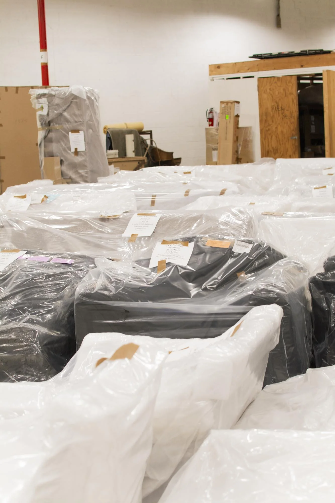 Warehouse filled with packaged furniture covered in plastic wrap