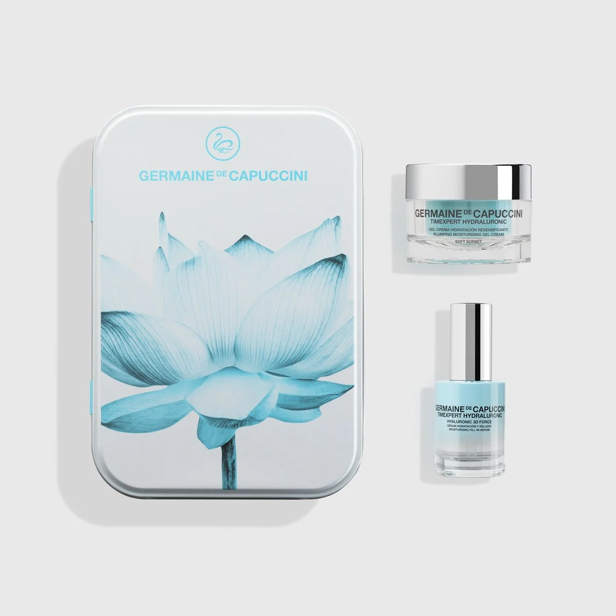 Set de productos de cuidado facial de la marca Germaine de Capuccini, que incluye una crema en un frasco de cristal y un sérum en un frasco con gotero, junto a una caja con ilustración de una flor en tonos azules y blancas.