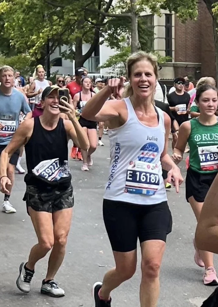 Julie Thornton smiling and running with fellow participants during the Chicago Marathon.