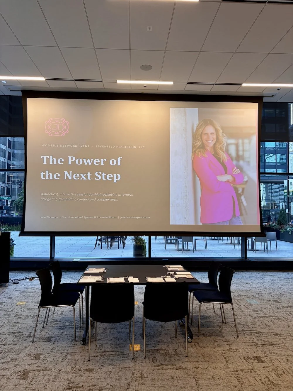 Presentation screen displaying 'The Power of the Next Step' title slide during Julie Thornton's keynote session at Levenfeld Pearlstein