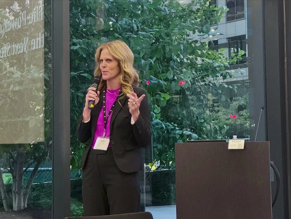 Julie Thornton speaking with a microphone at the Levenfeld Pearlstein Women's Network event for The Power of the Next Step presentation