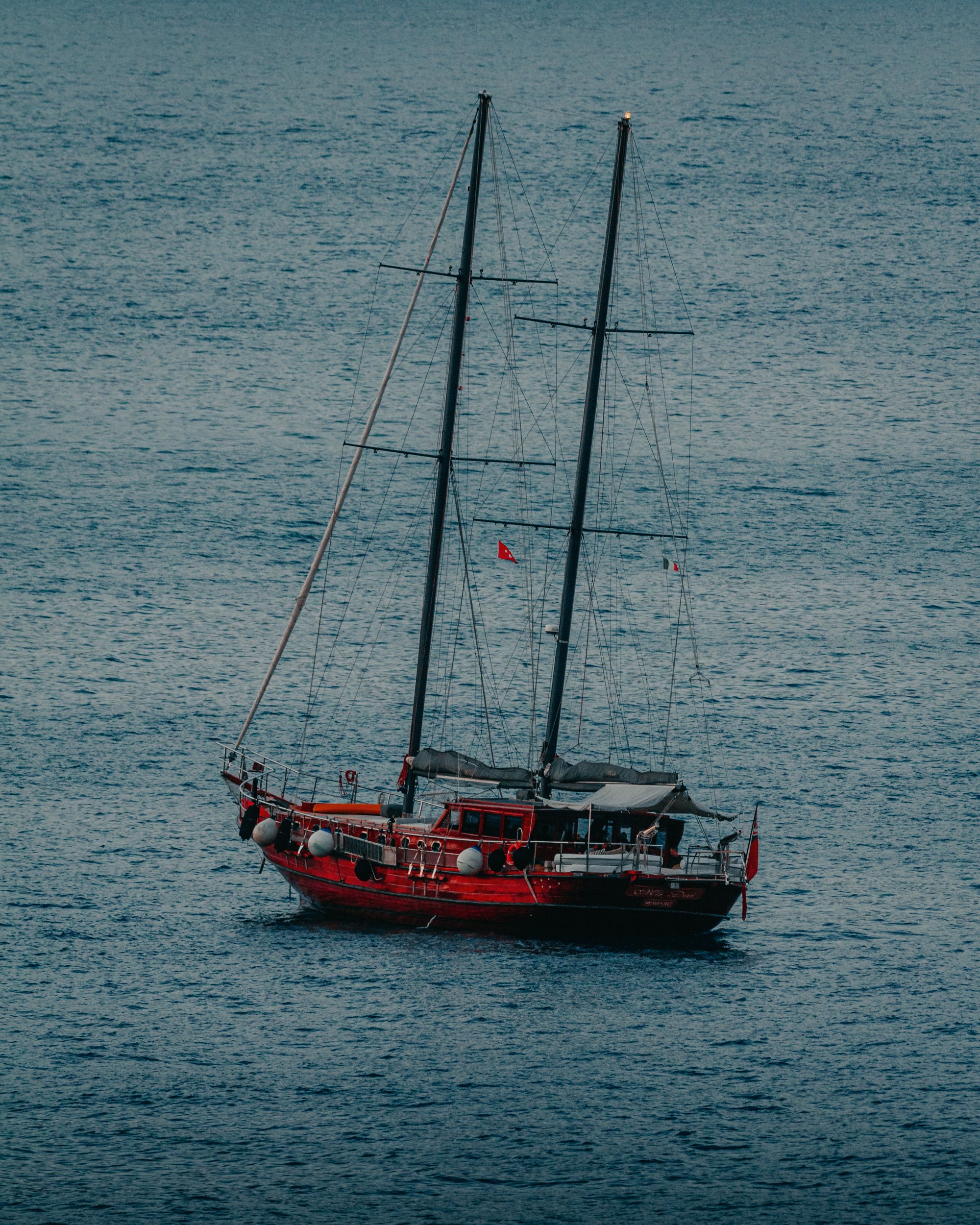 Veliero rosso a due alberi su mare calmo