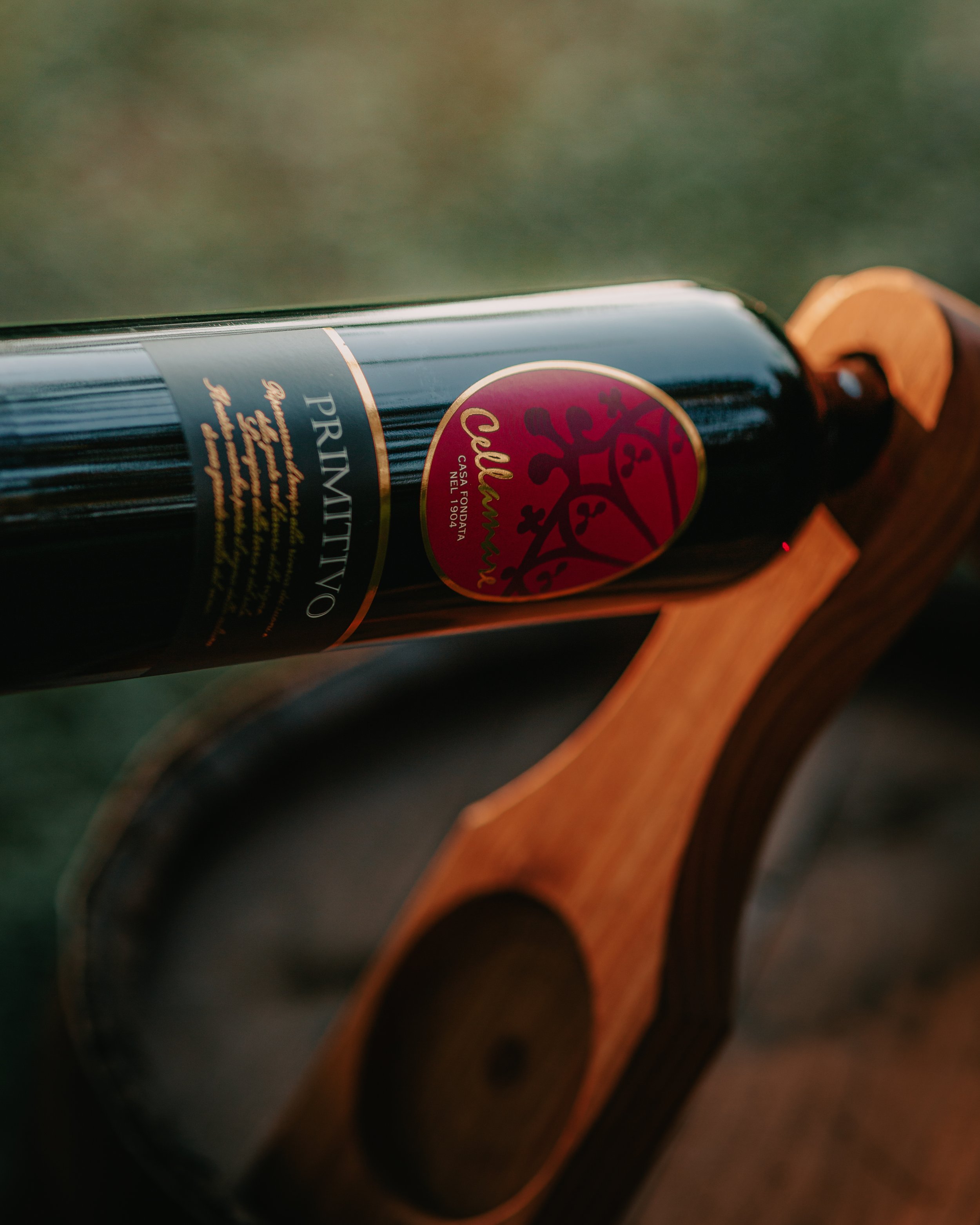 Bottiglia di vino Primitivo in un supporto di legno.
