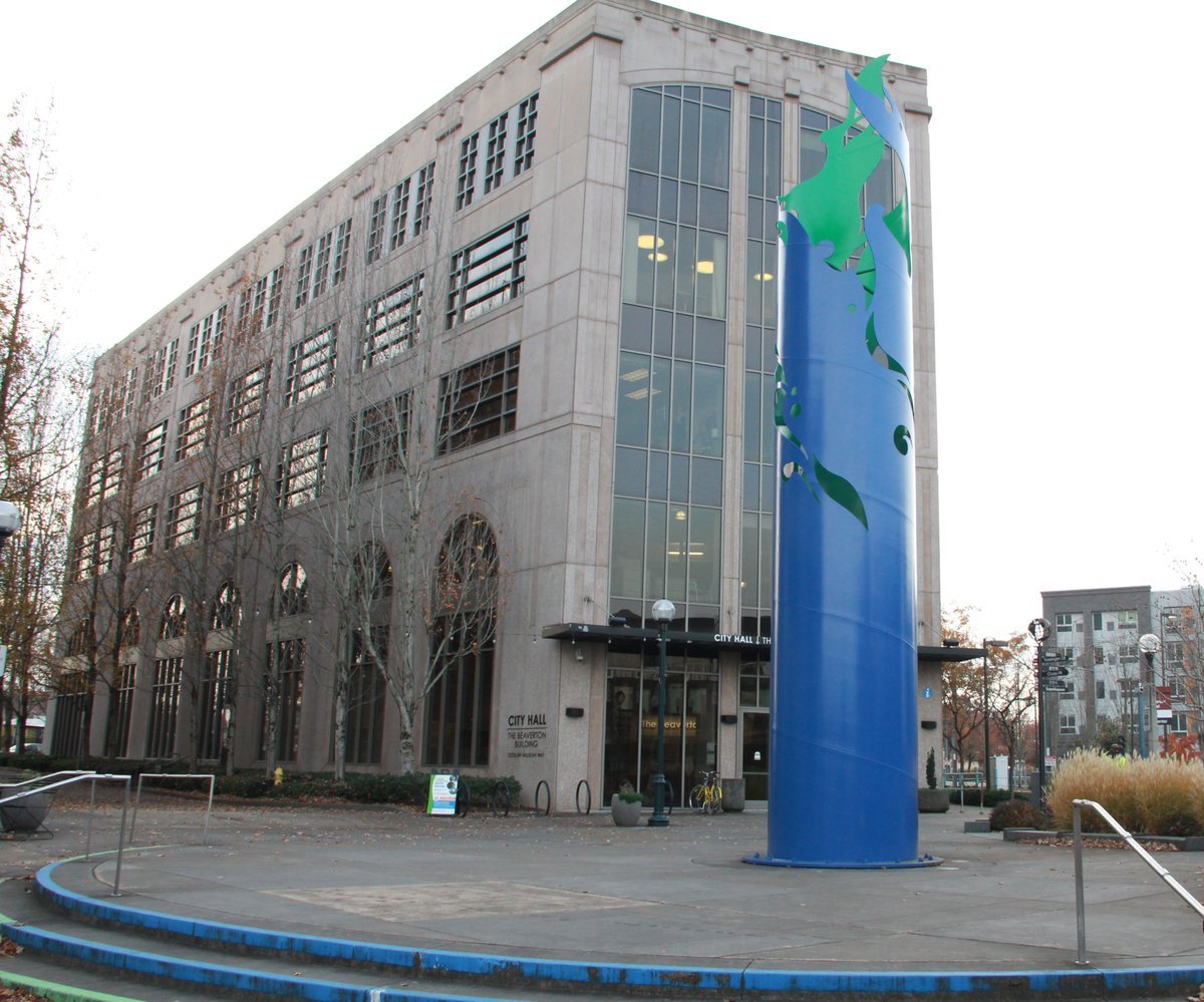 City Hall building with a tall abstract blue and green sculpture outside.