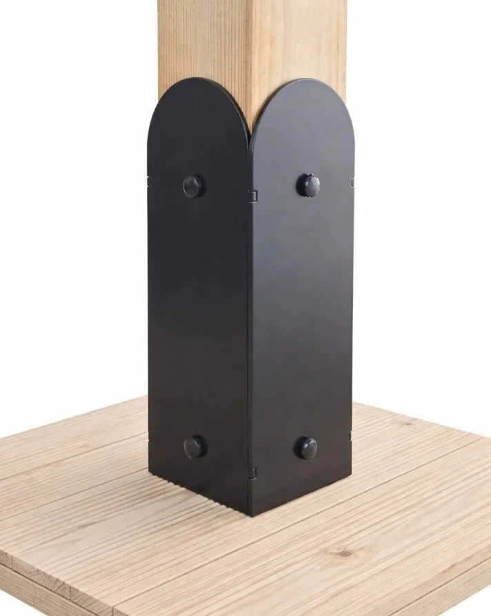Black corner brace with two sides and round knobs, attached to a wooden post on a wooden surface.