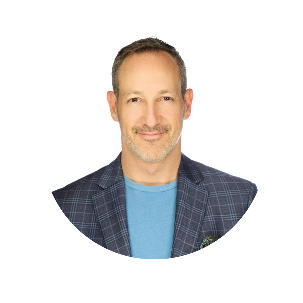 Headshot of middle-aged man with short brown hair, beard, and mustache, smiling, wearing a blazer over a blue t-shirt, against a white background.
