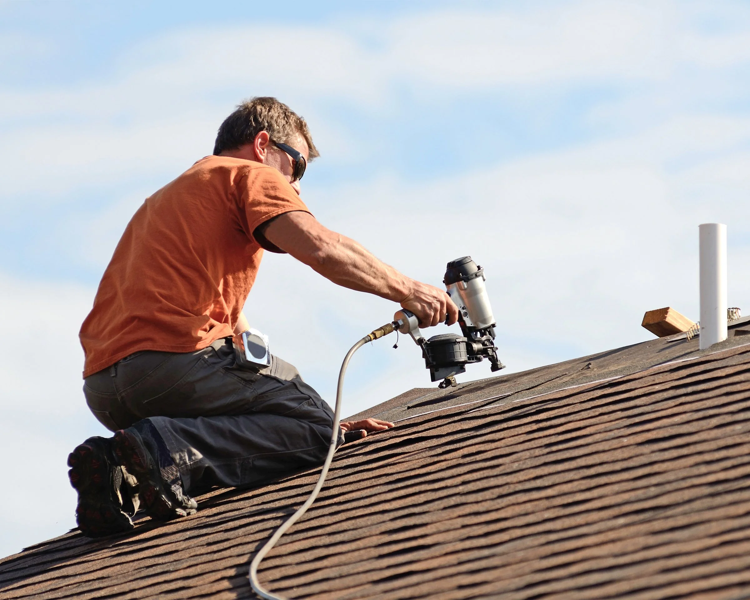 Professional roofing contractor installing roof shingles on a home.