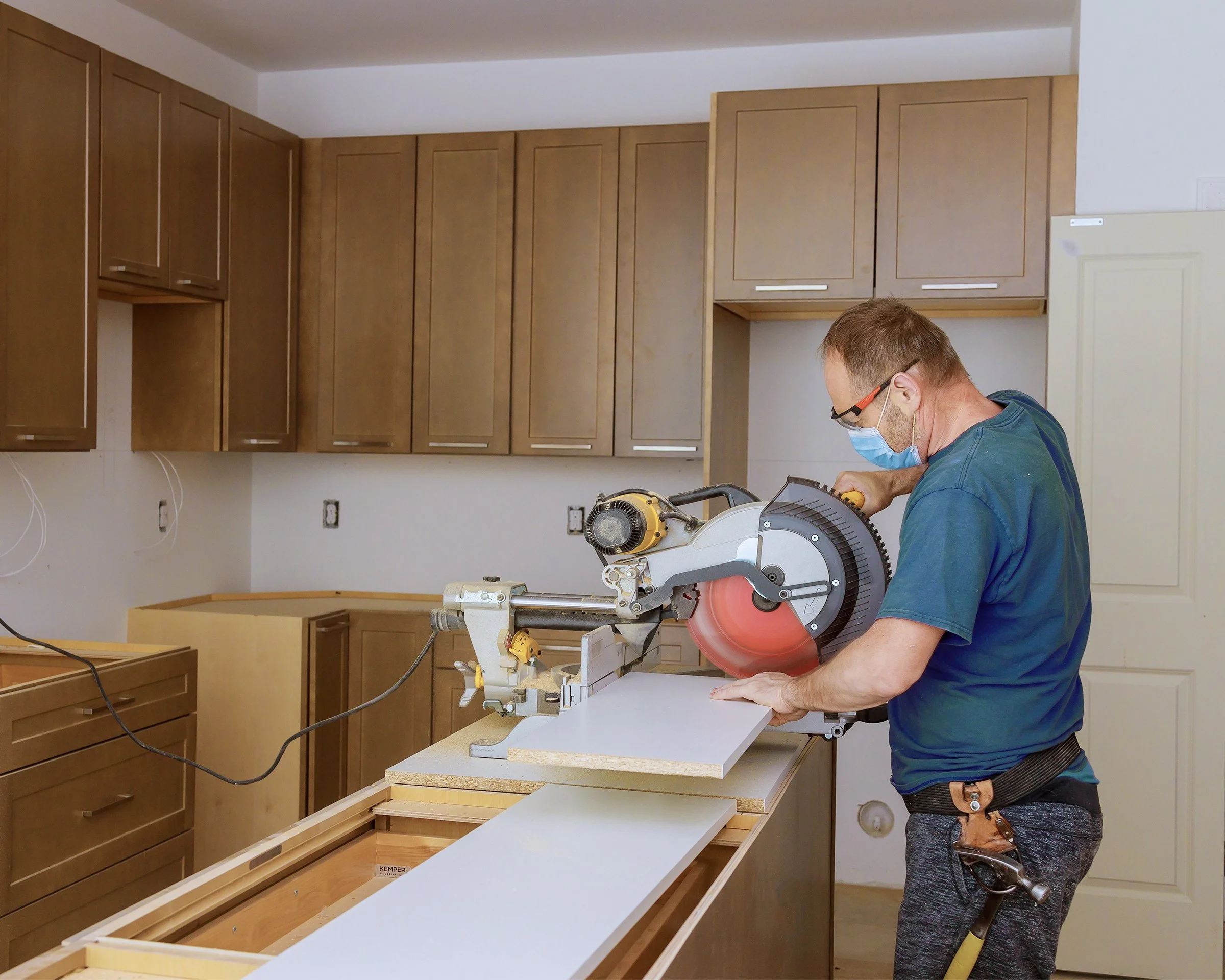 Carpenter working on kitchen cabinets in a home renovation.