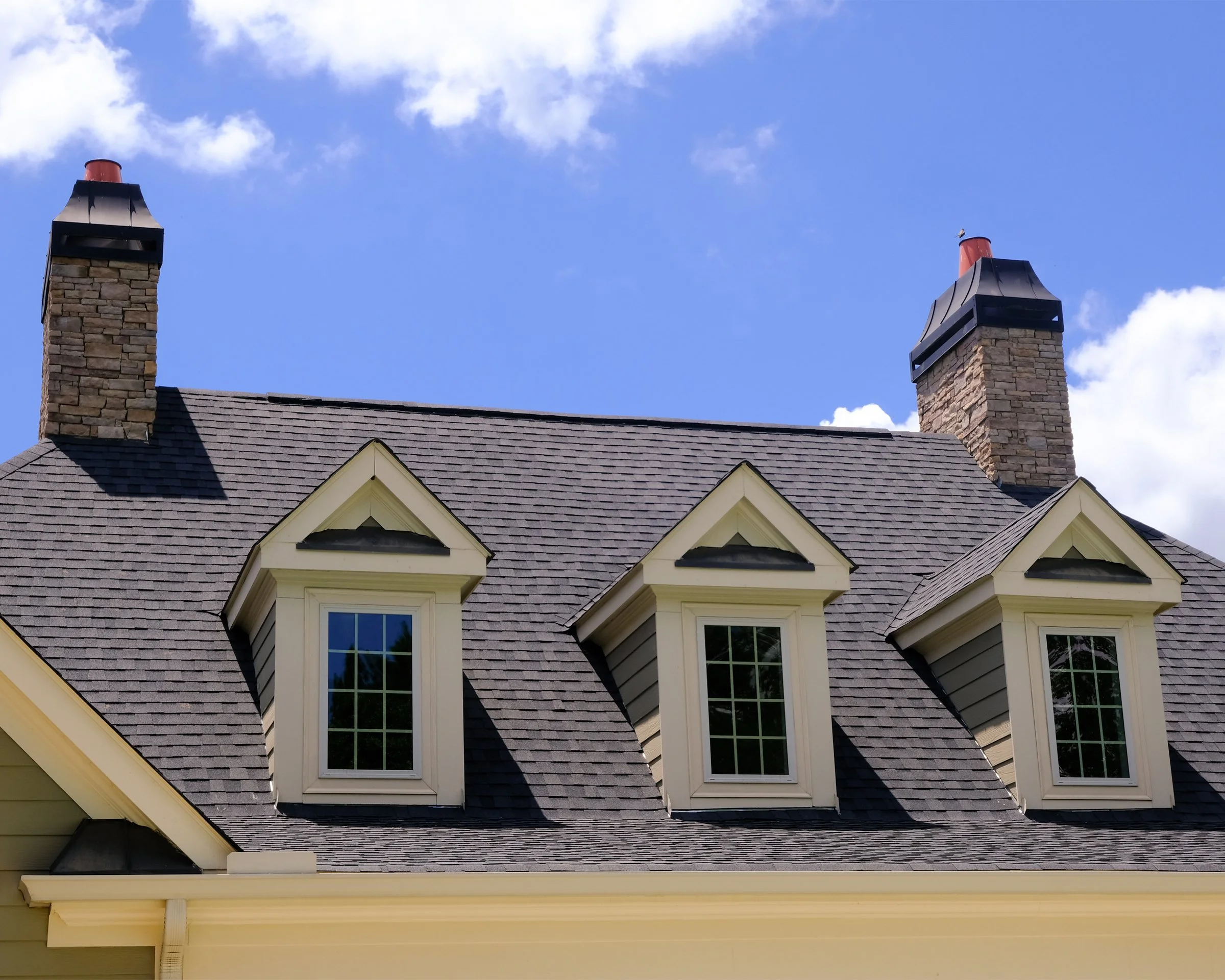 House roof with dormer windows and chimneys.